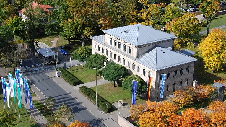 Historisches Gebäude der kaufmännischen Direktion schräg von der Seite aus der Luft zu sehen.