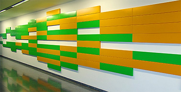 Das Werk hat die Form einer in die Breite gezogenen verpixelten grün-gelben Raute. Links sind mehr grüne Rechtecke, rechts mehr gelbe und in der Mitte eine Mischung aus beiden Farben.